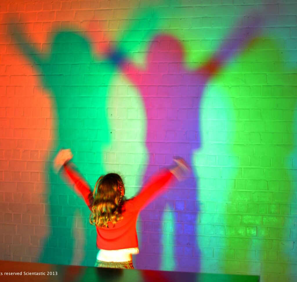 A child playing with coloured shadows